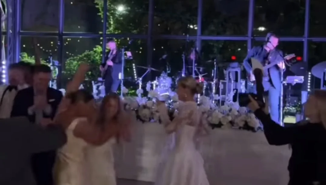 Bride and guests dancing as Lost Wax performs inside the glass orangery at Erin + Mat's wedding at Avent Orangery in Kansas City, KS on May 1, 2026