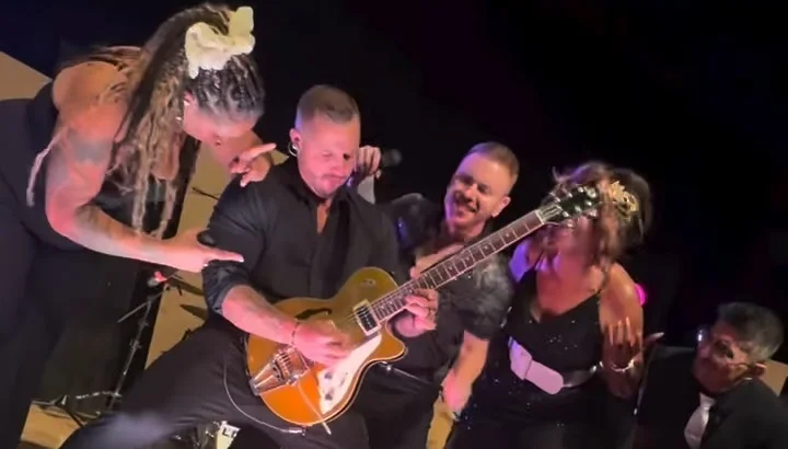 Lost Wax band members gathered around the guitarist at the front of the stage at the Nebraska Wedding Day Best of 2026 Awards Gala at The Leo Ballroom in Omaha, NE on June 16, 2026
